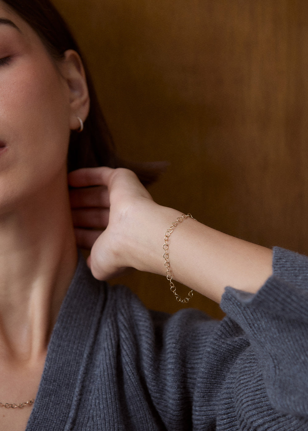 Close-up of a 9k yellow gold hammered-link bracelet worn on a raised wrist.