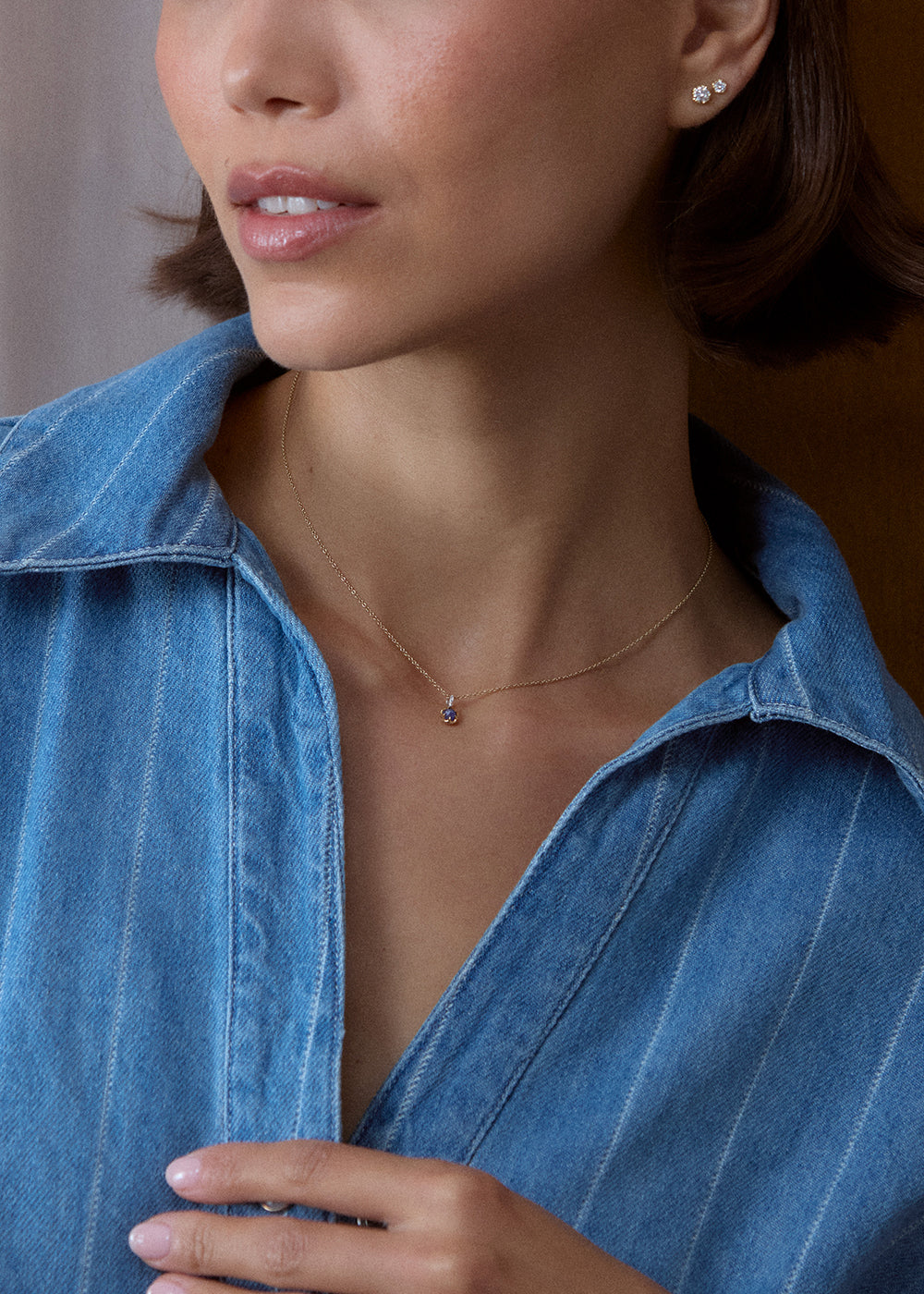 Round deep blue sapphire charm in a scalloped 18k gold vermeil setting, worn on a fine chain.