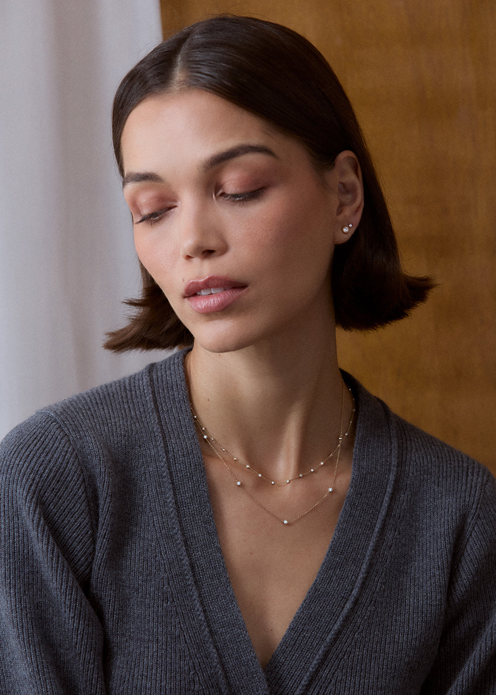 9k yellow gold fine-chain necklace with spaced lab-grown diamonds, worn with a grey cardigan.