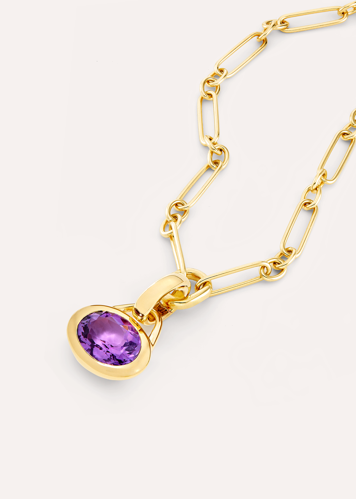 Close-up of an oval purple amethyst pendant on an 18k gold vermeil rectangular-link chain.