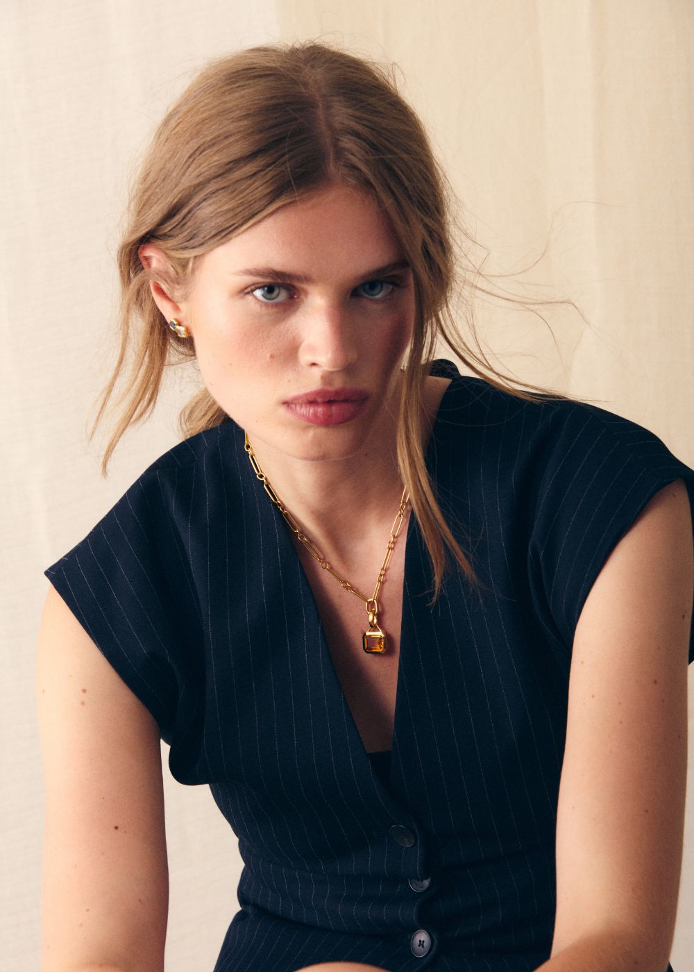 18k gold vermeil orange citrine pendant necklace worn with a dark top, seated portrait.